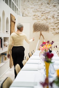 a woman standing in front of a long table